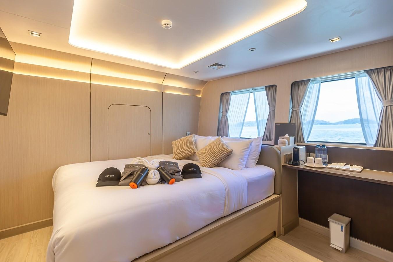 a bedroom with a bed and a desk aboard VANORA Yacht for Sale