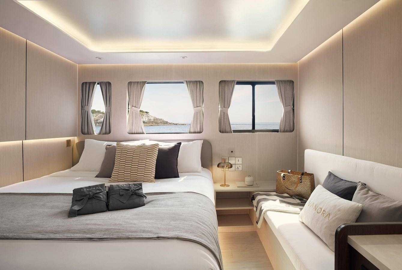 a bedroom with a bed and a window aboard VANORA Yacht for Sale