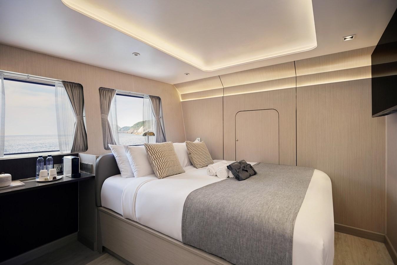 a bedroom with a bed and a window aboard VANORA Yacht for Sale