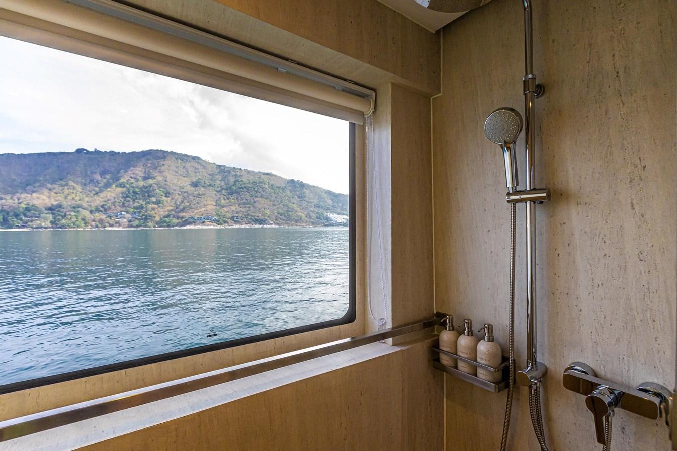 a window with a view of the mountains and water below aboard VANORA Yacht for Sale
