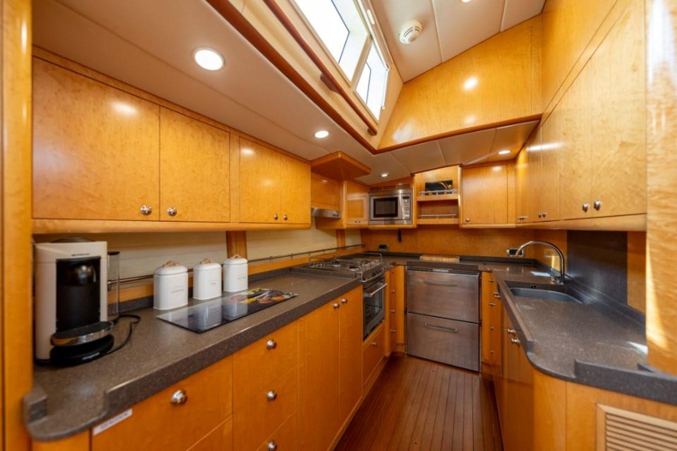 a kitchen with wooden cabinets aboard ECOVER OF SKAGEN Yacht for Sale