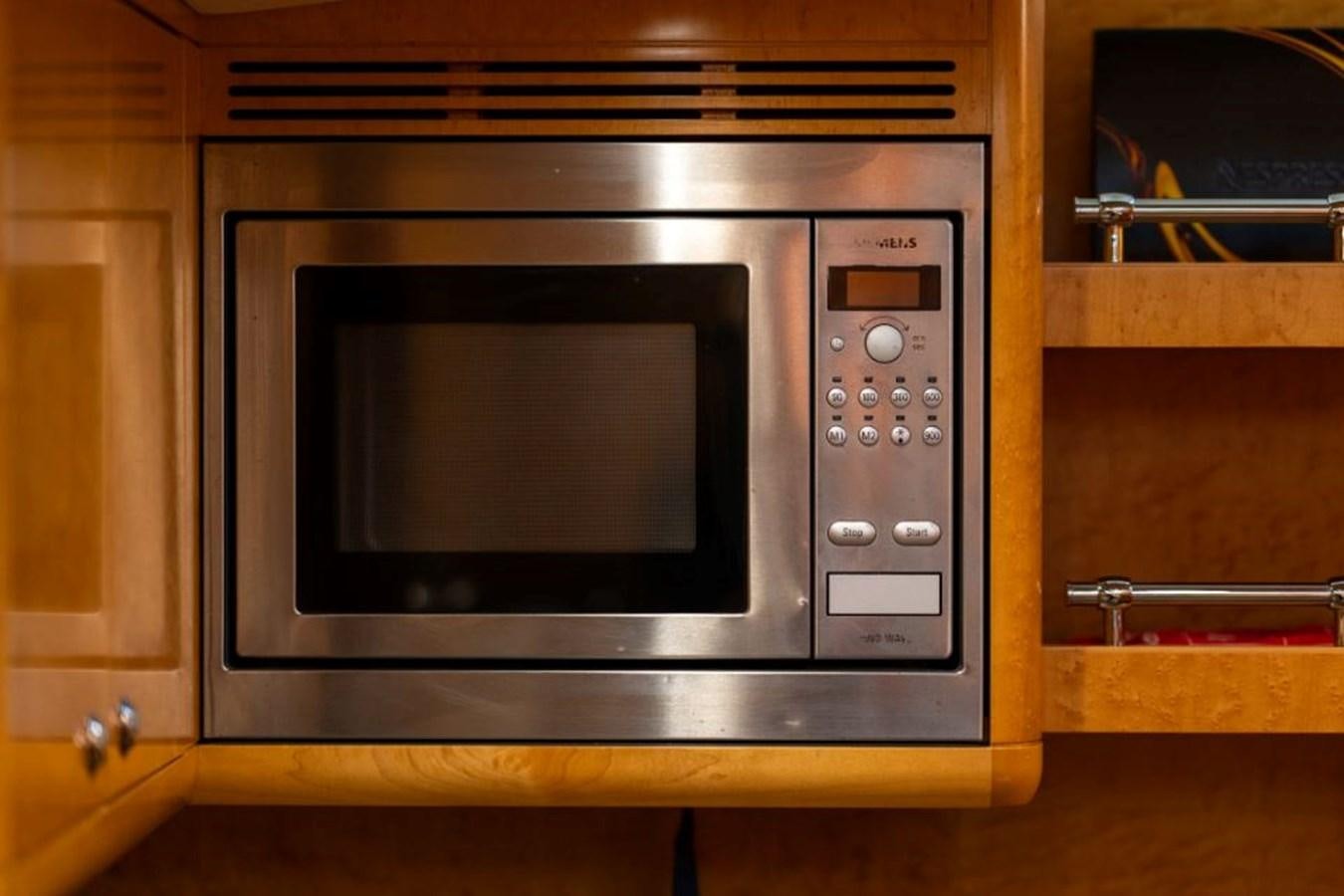 a microwave oven in a wooden cabinet aboard ECOVER OF SKAGEN Yacht for Sale
