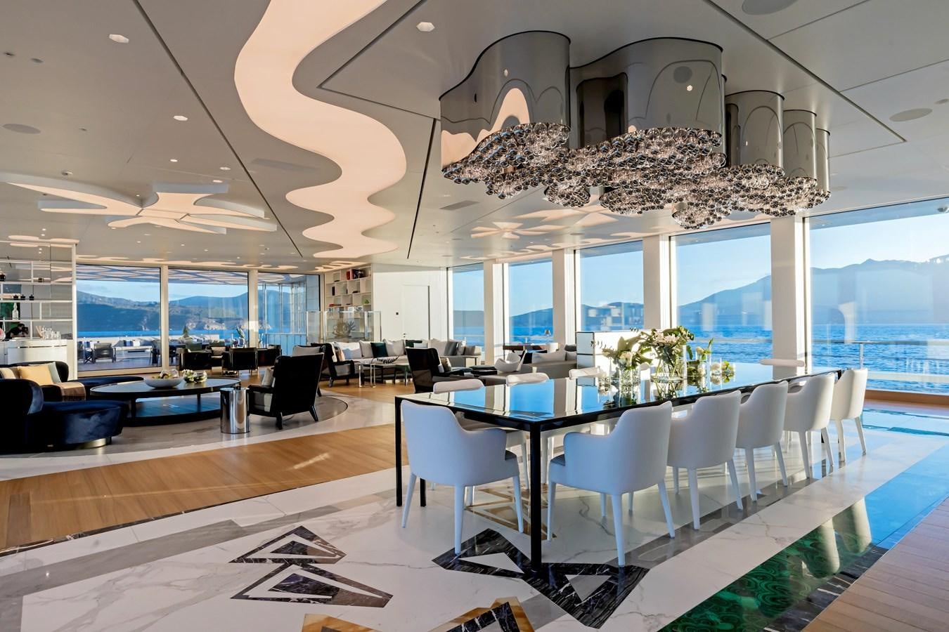 a room with tables and chairs aboard LUMINOSITY Yacht for Sale