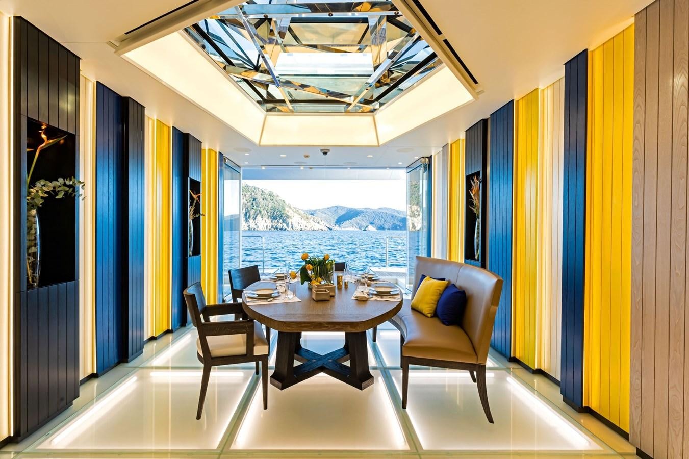 a room with a table chairs and a window aboard LUMINOSITY Yacht for Sale