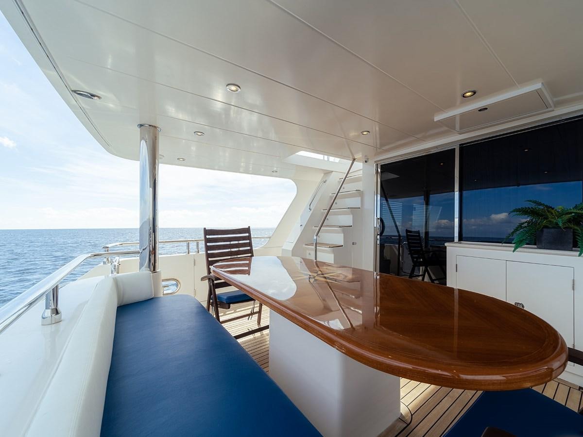 a large open space with a table and chairs and a large window aboard ISOBEL III Yacht for Sale