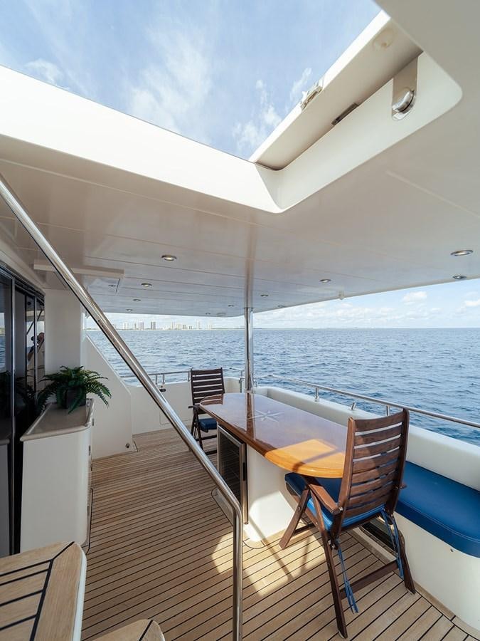 a deck with chairs and a table on it aboard ISOBEL III Yacht for Sale