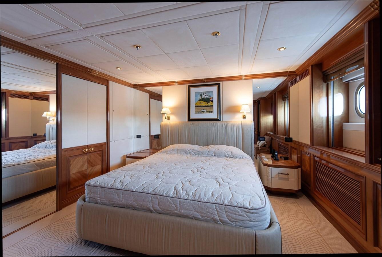 a room with a bed and a mirror aboard PETARA Yacht for Sale