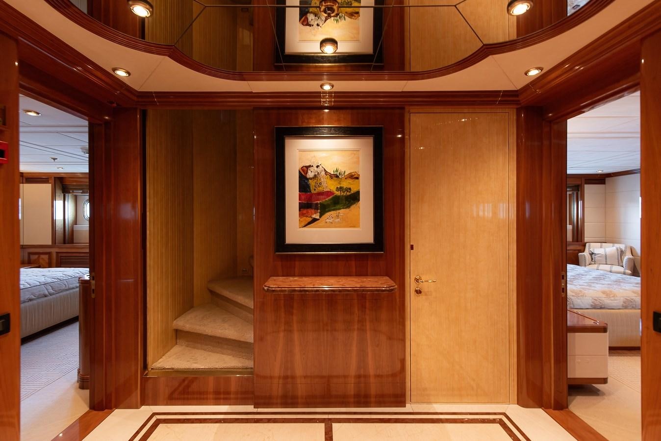 a room with a wood door and a painting on the wall aboard PETARA Yacht for Sale