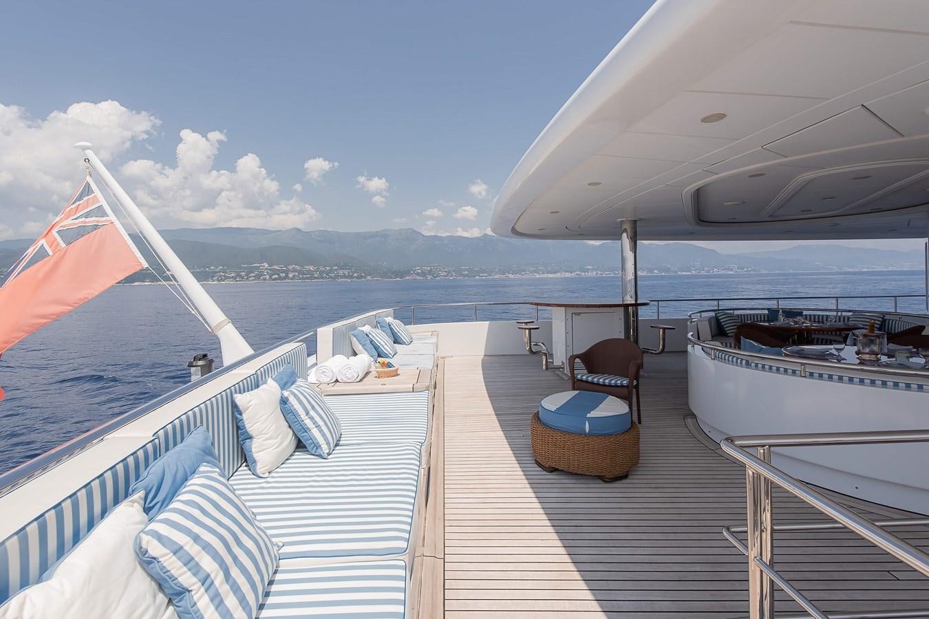 a deck with a chair and a boat on it aboard PETARA Yacht for Sale