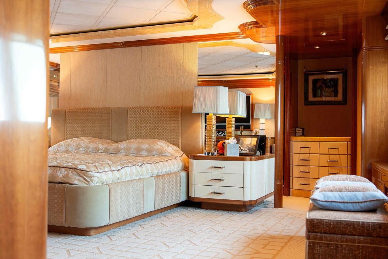 a bedroom with a bed and a lamp aboard PETARA Yacht for Sale