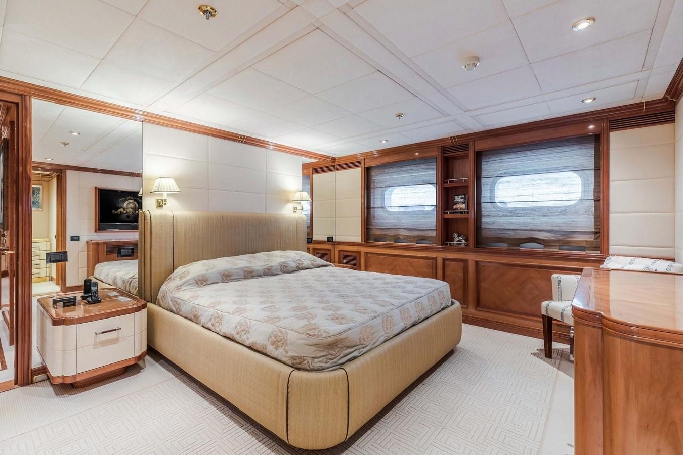 a bedroom with a bed and a television aboard PETARA Yacht for Sale