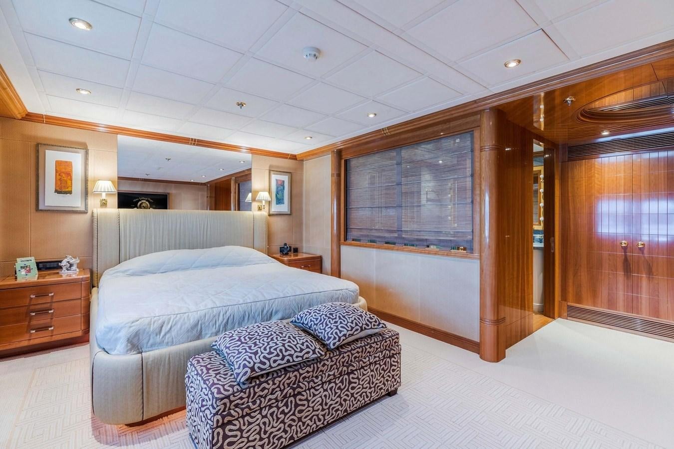 a bedroom with a bed and a chair aboard PETARA Yacht for Sale