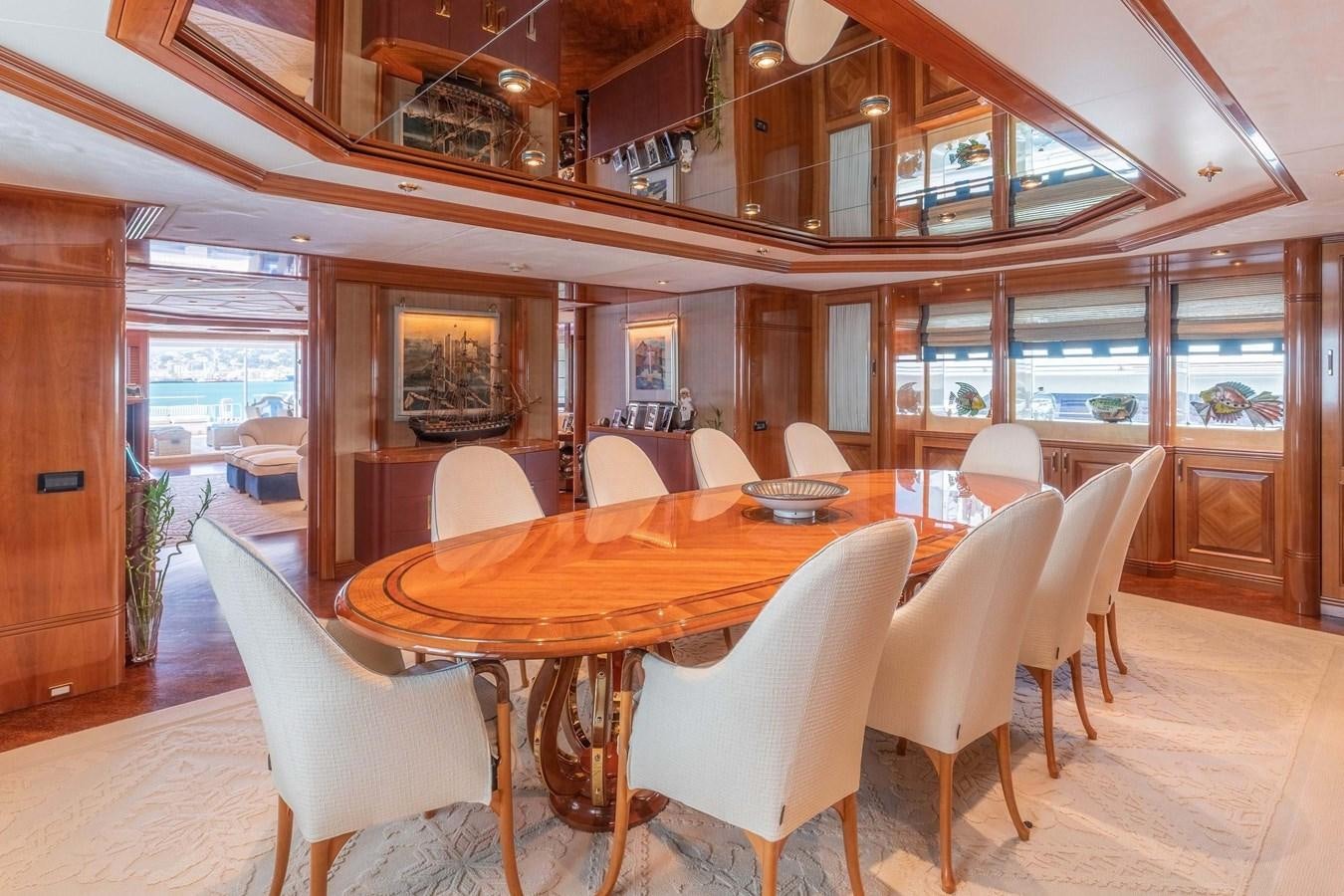 a large dining table with white chairs aboard PETARA Yacht for Sale