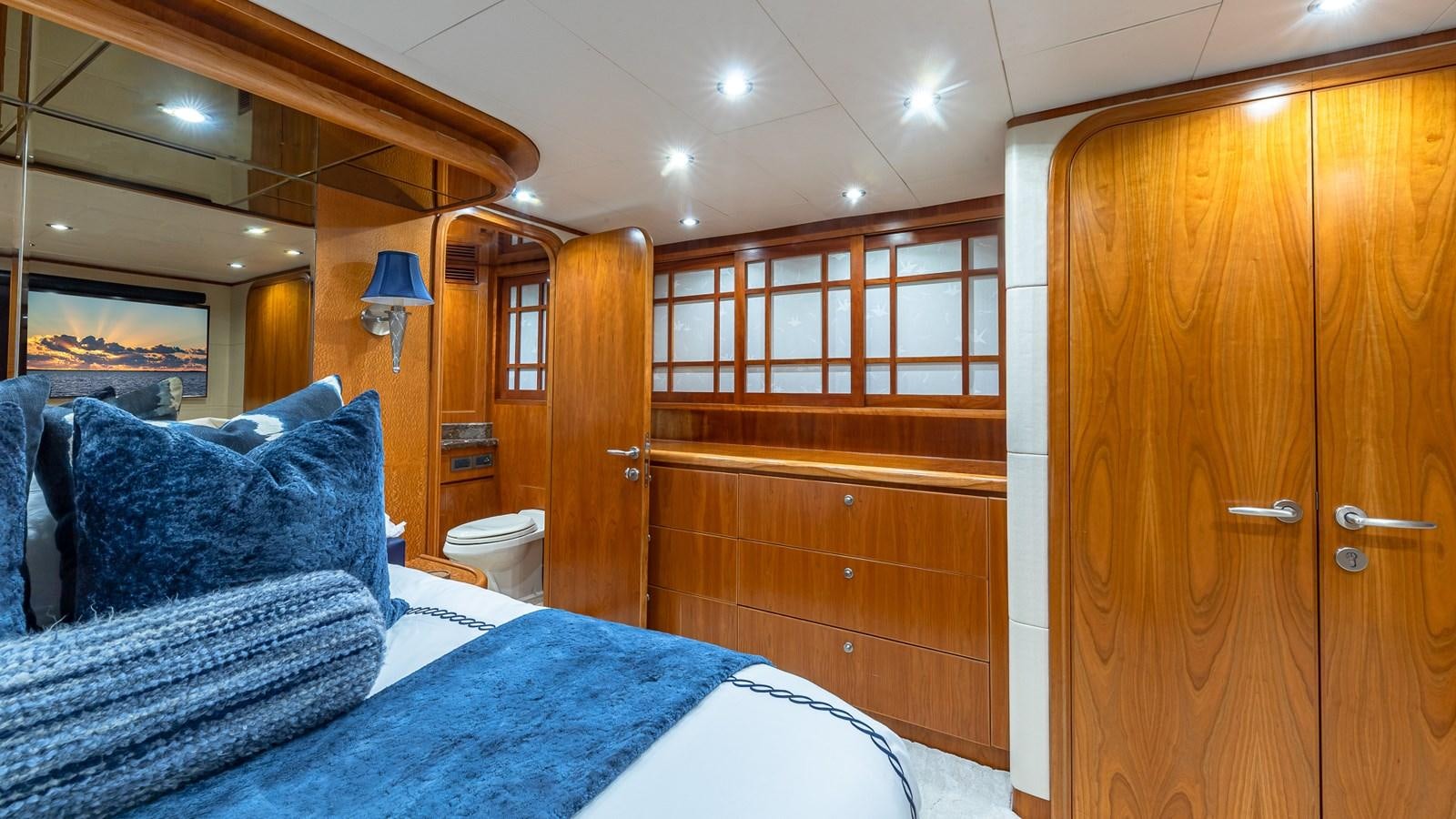 a bedroom with a bed and a wood closet aboard B HAPPY Yacht for Sale