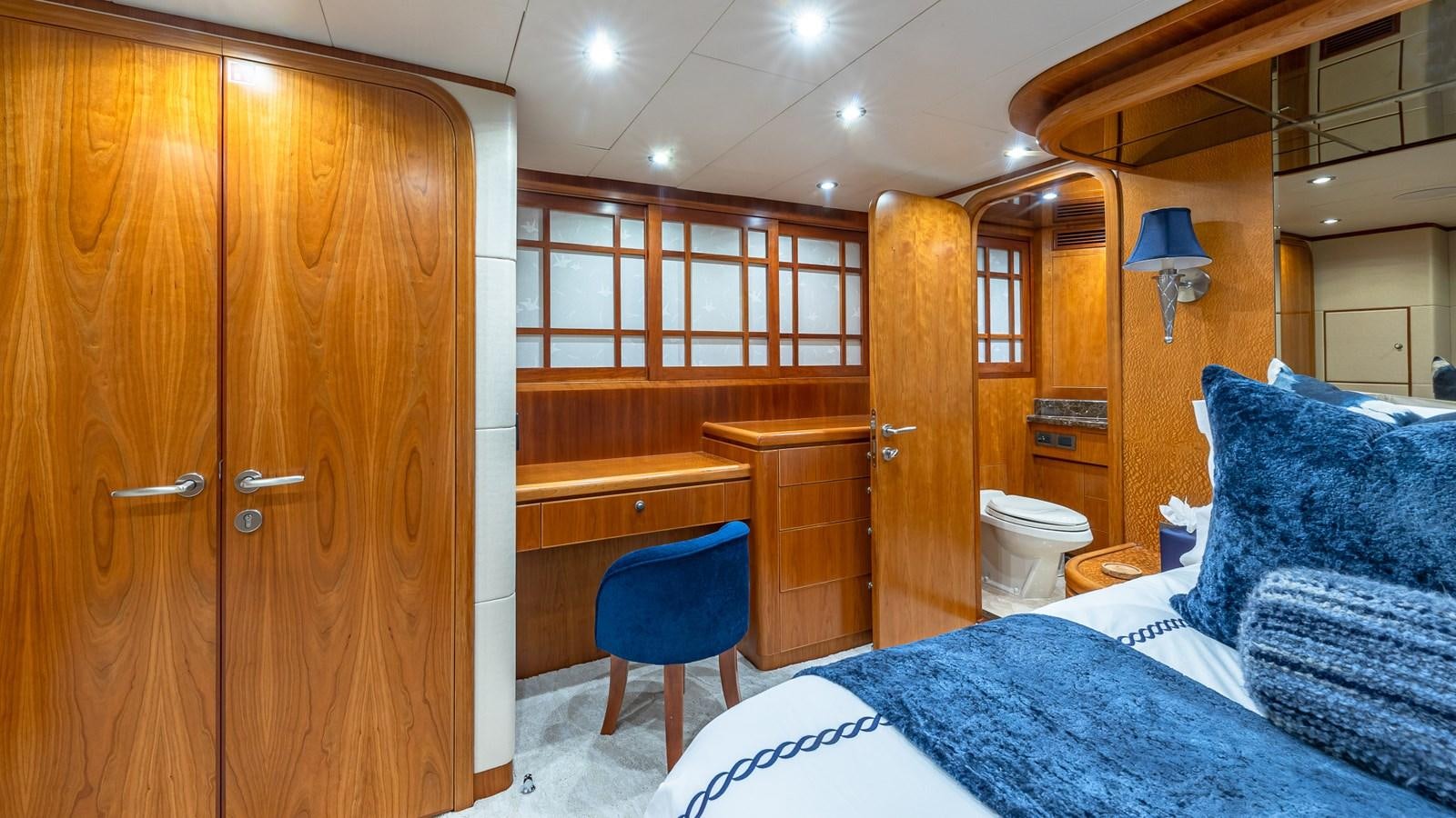 a bedroom with wood cabinets aboard B HAPPY Yacht for Sale
