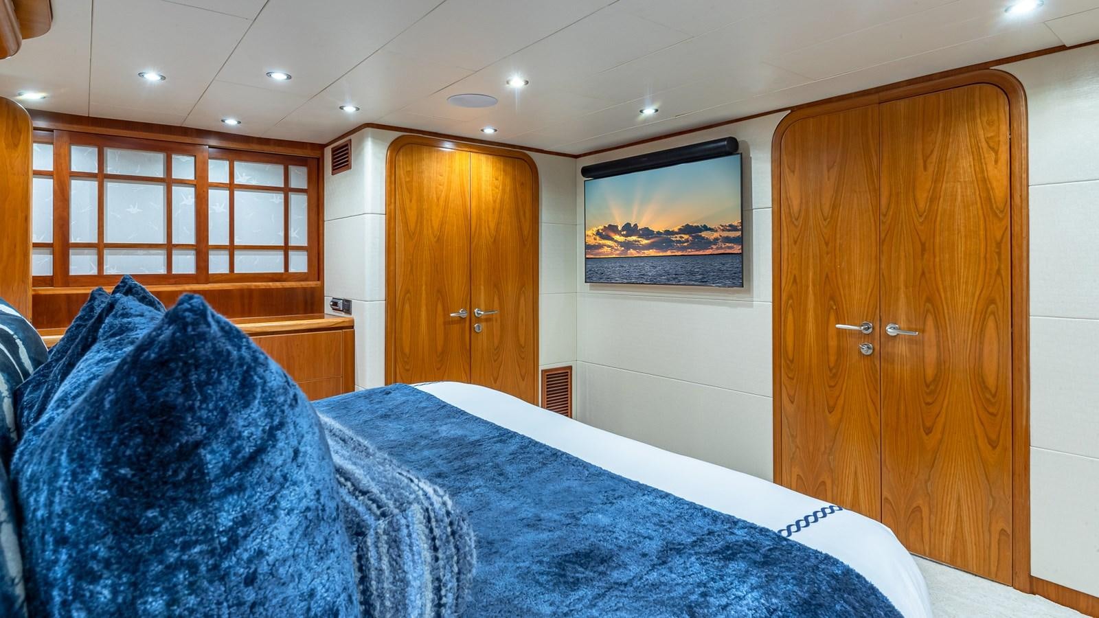 a bedroom with a bed and a wood door aboard B HAPPY Yacht for Sale