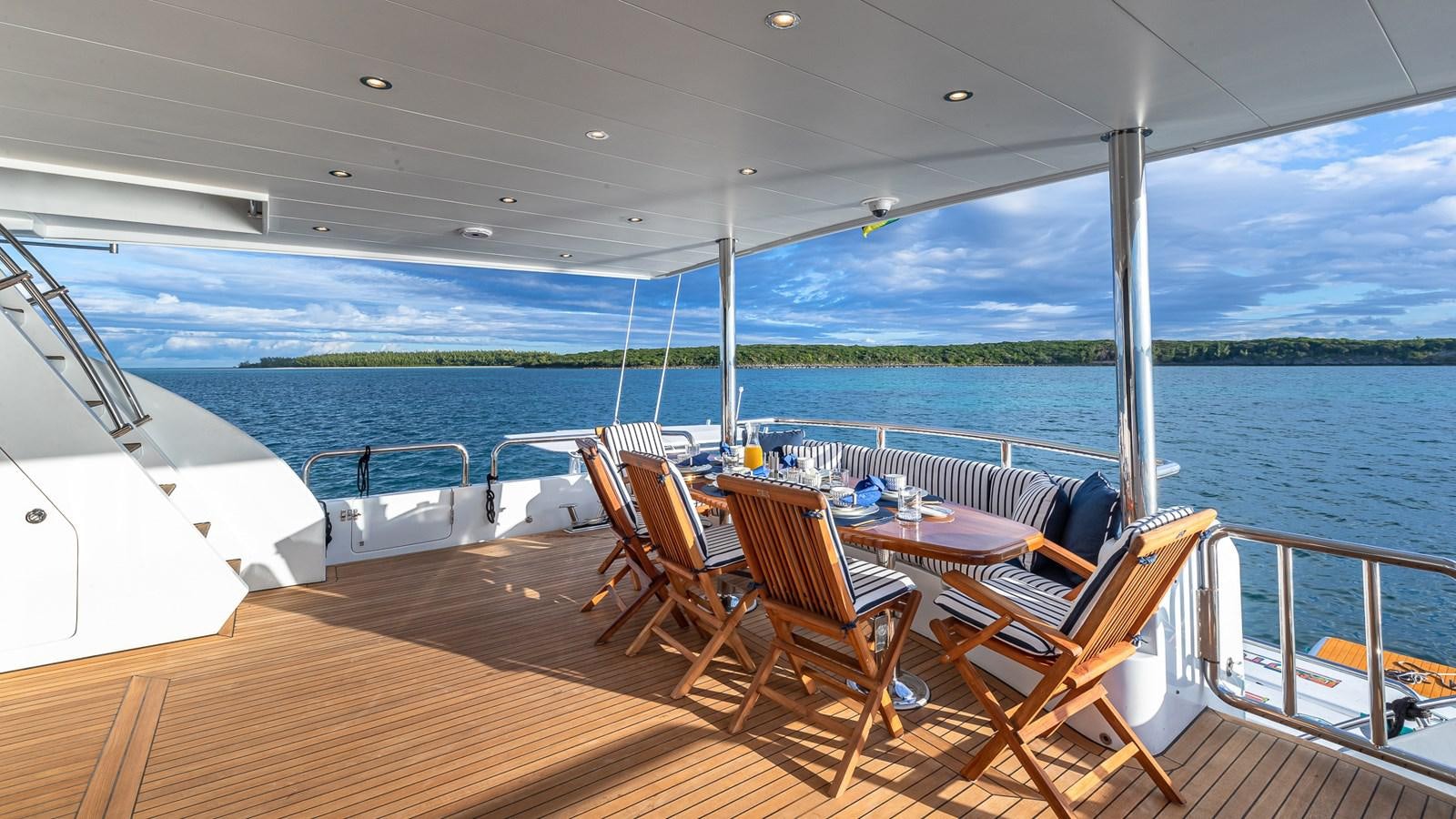 a deck with chairs and tables on it aboard B HAPPY Yacht for Sale