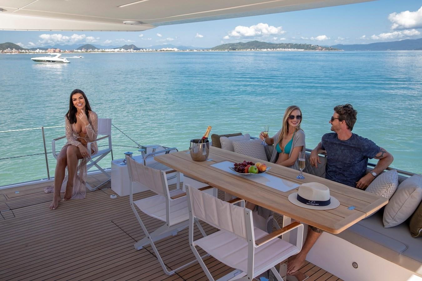a group of people sitting around a table on a deck overlooking the ocean aboard SCHAEFER 660 Yacht for Sale