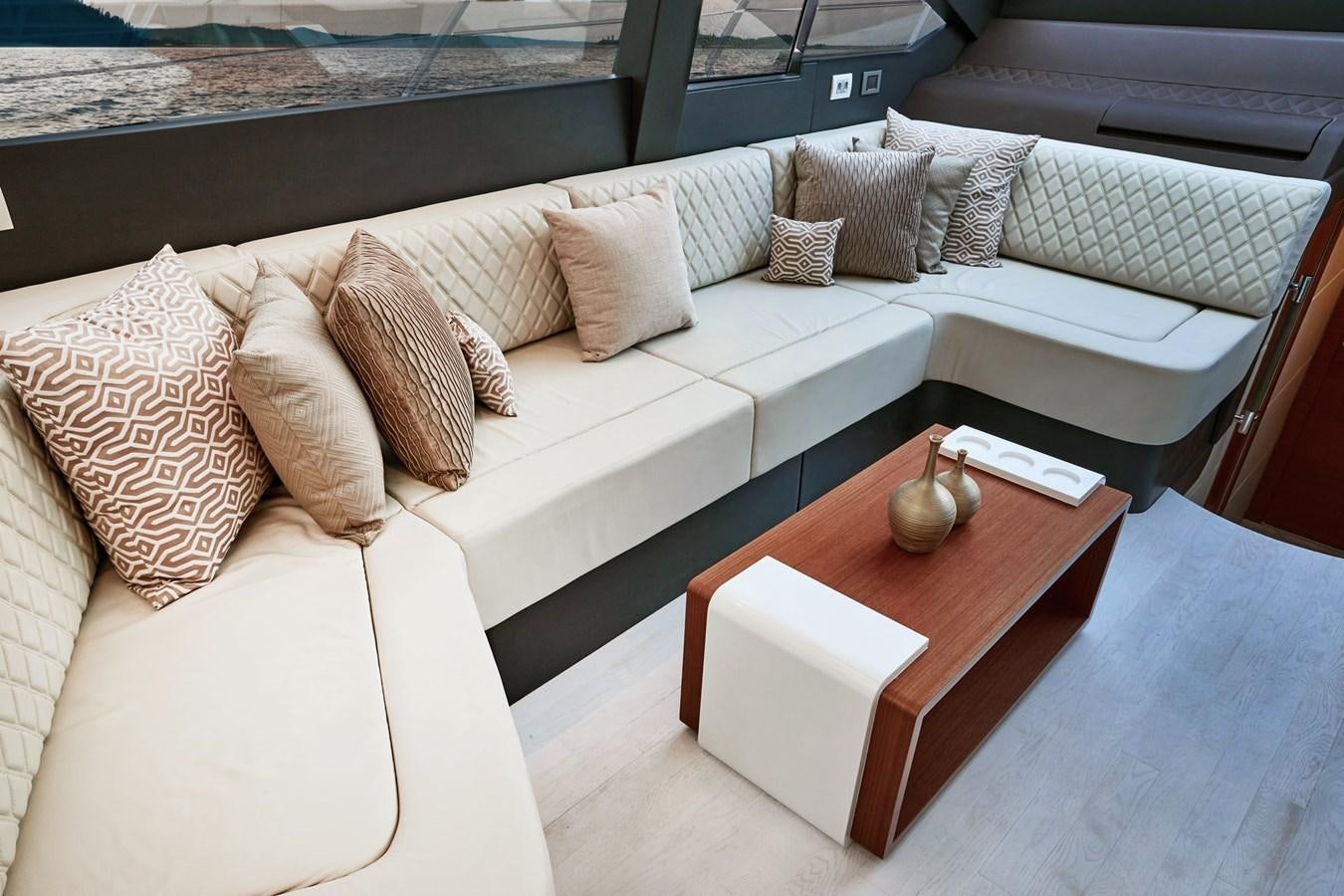 a couch with pillows and a coffee table in a room aboard SCHAEFER 660 Yacht for Sale