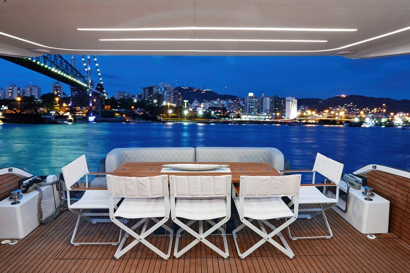 a table and chairs on a deck overlooking a city and water aboard SCHAEFER 660 Yacht for Sale