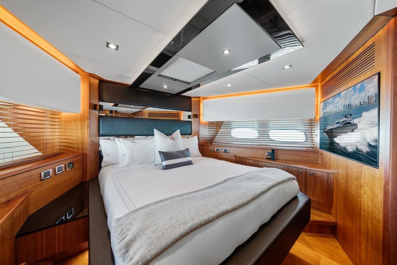 a bedroom with a bed and a window aboard PREDATOR 84 Yacht for Sale