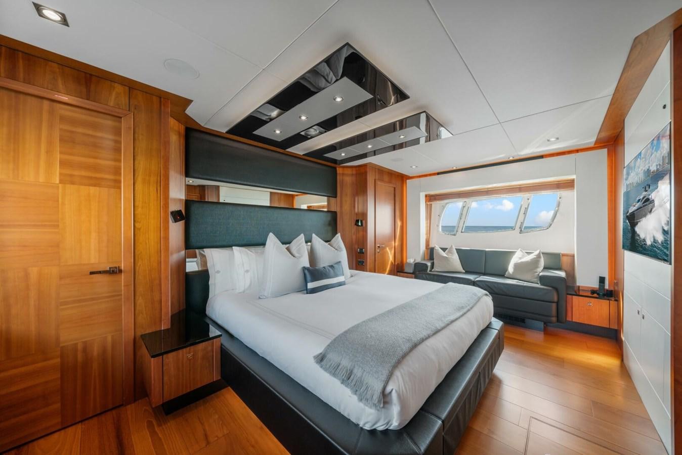 a bedroom with a bed and a wood cabinet aboard PREDATOR 84 Yacht for Sale