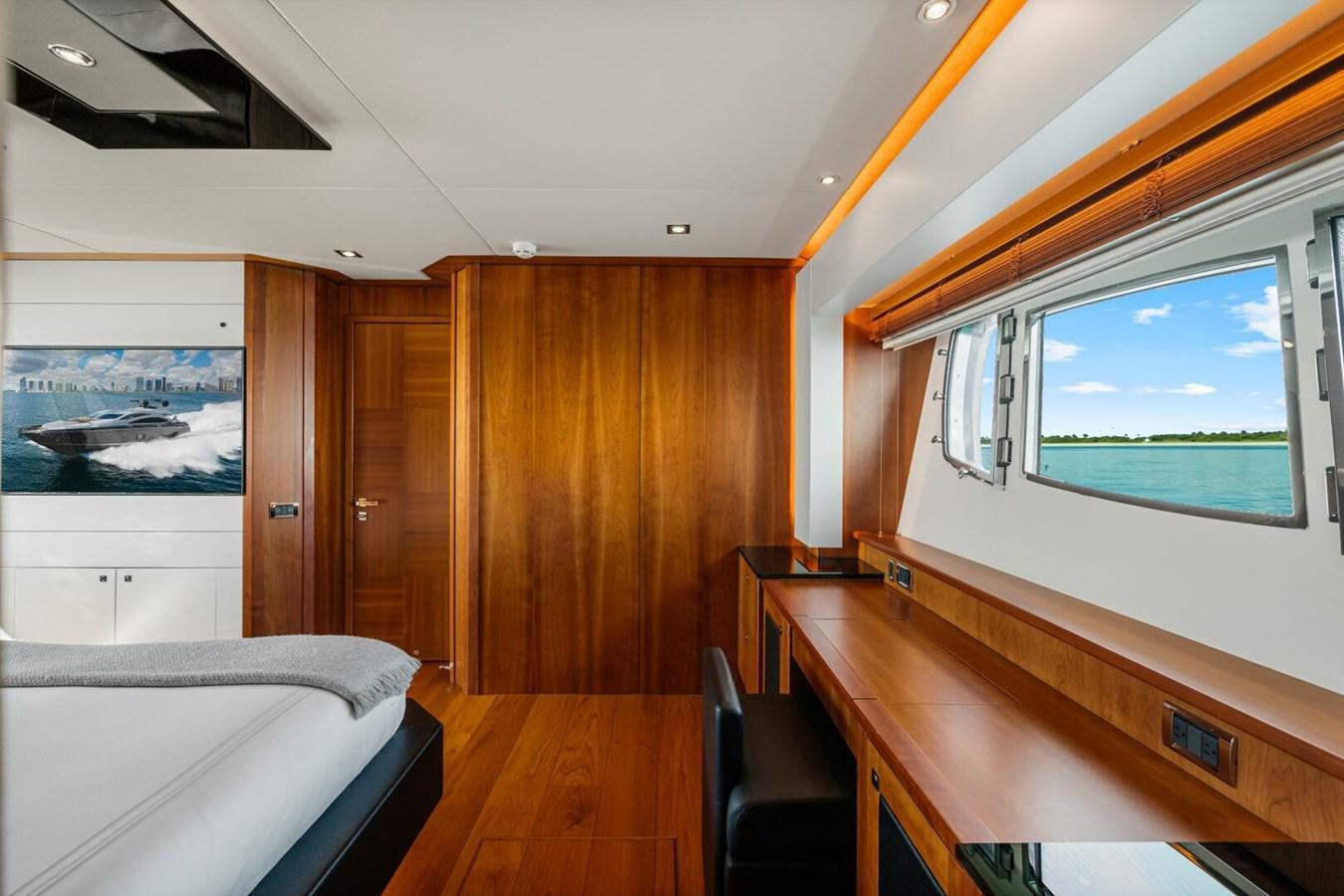 a room with a bed and a desk aboard PREDATOR 84 Yacht for Sale