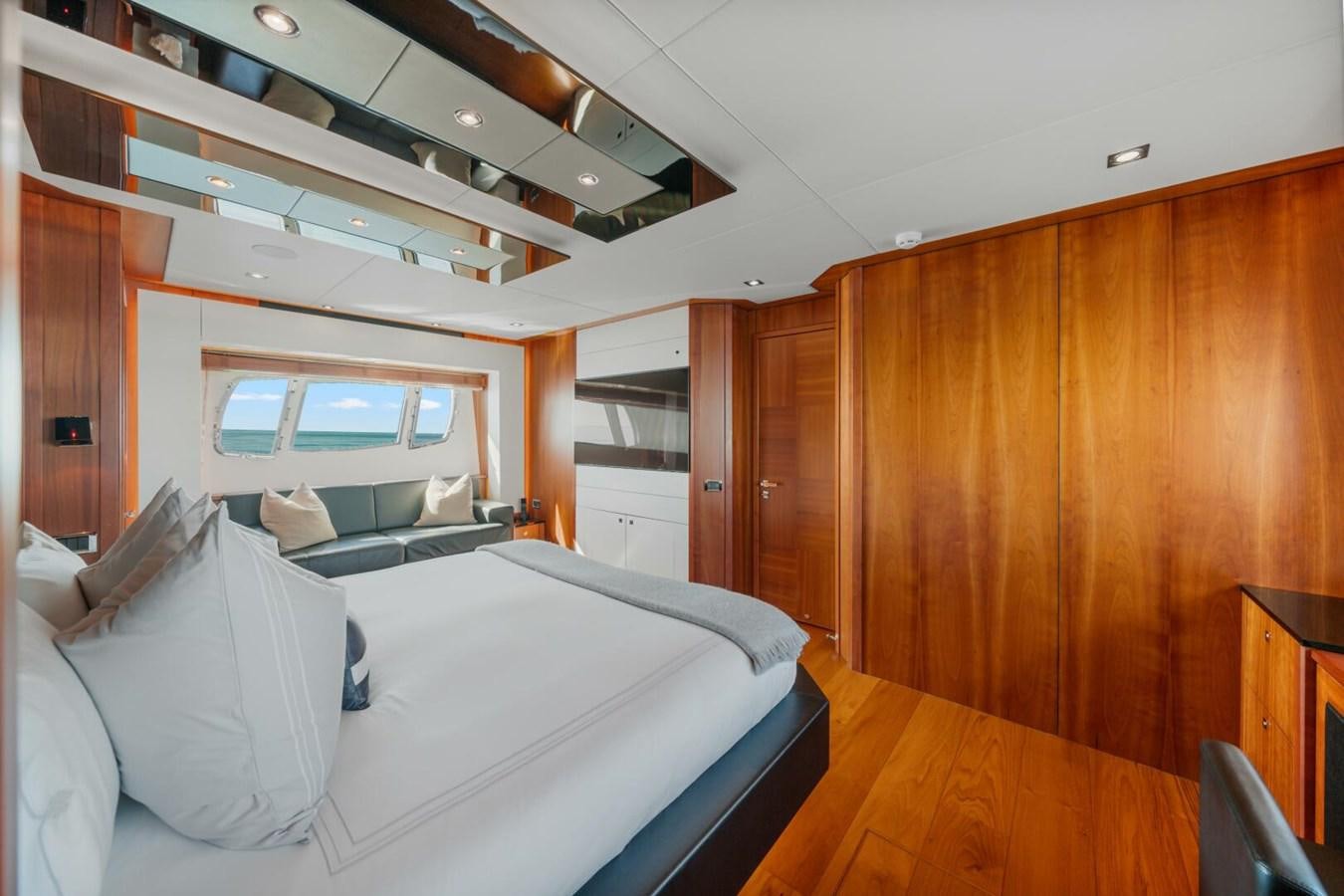 a room with a bed and a wood cabinet aboard PREDATOR 84 Yacht for Sale