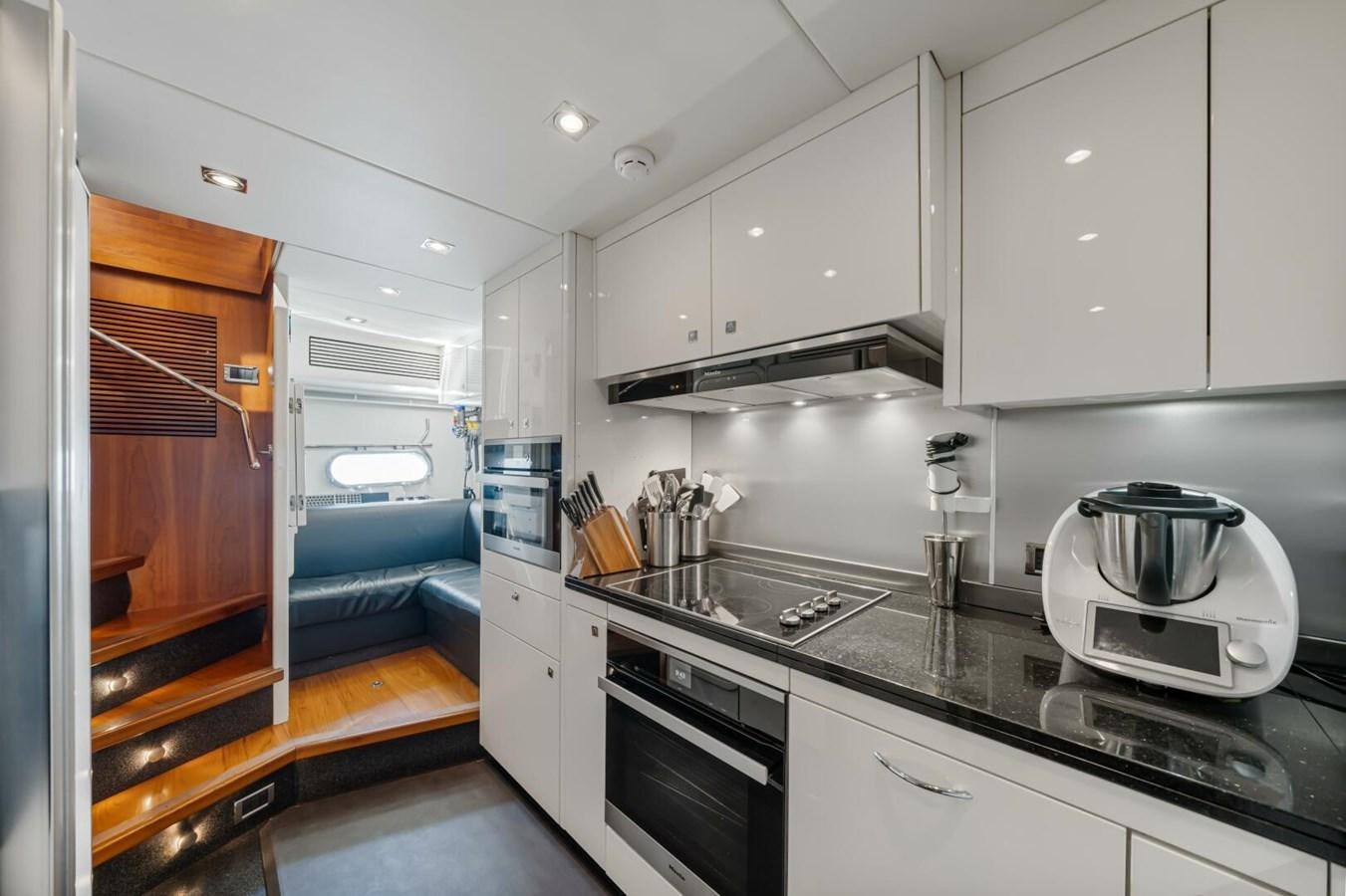 a kitchen with a stove and a microwave aboard PREDATOR 84 Yacht for Sale