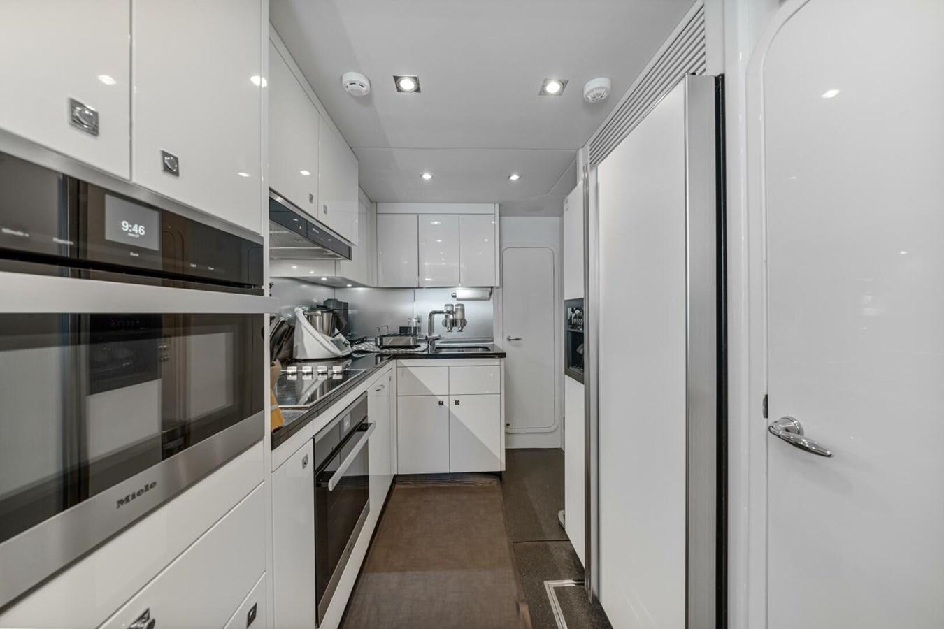 a kitchen with white cabinets aboard PREDATOR 84 Yacht for Sale