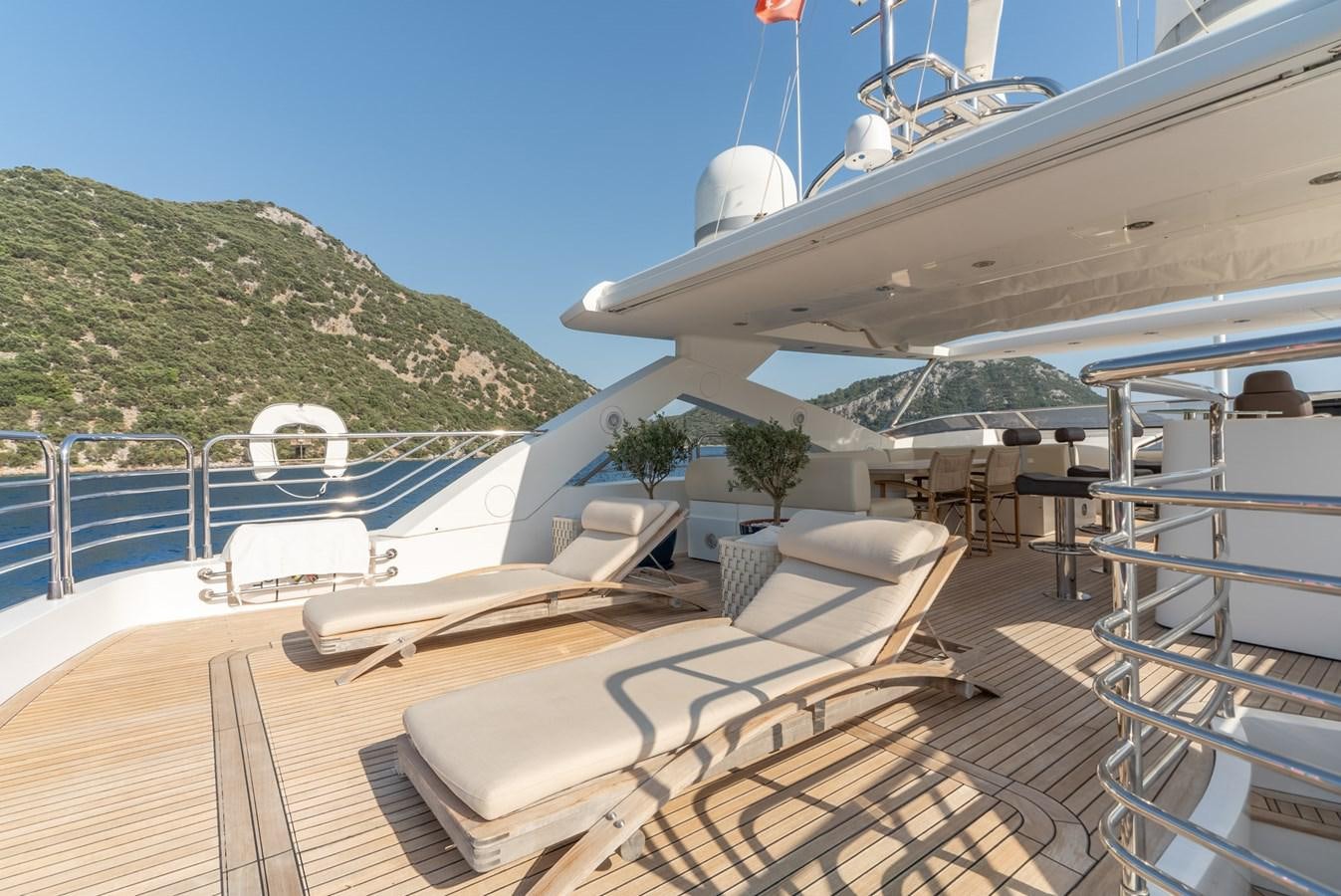 a deck with a view of the ocean and mountains aboard ROUND MIDNIGHT Yacht for Sale