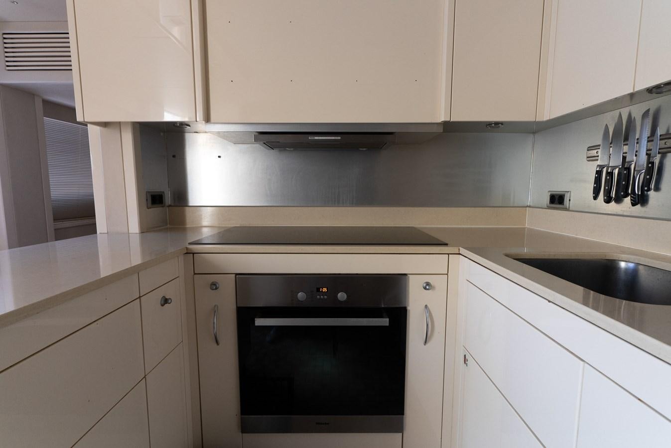 a kitchen with white cabinets aboard ROUND MIDNIGHT Yacht for Sale