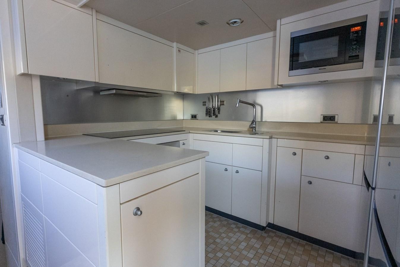 a kitchen with white cabinets aboard ROUND MIDNIGHT Yacht for Sale