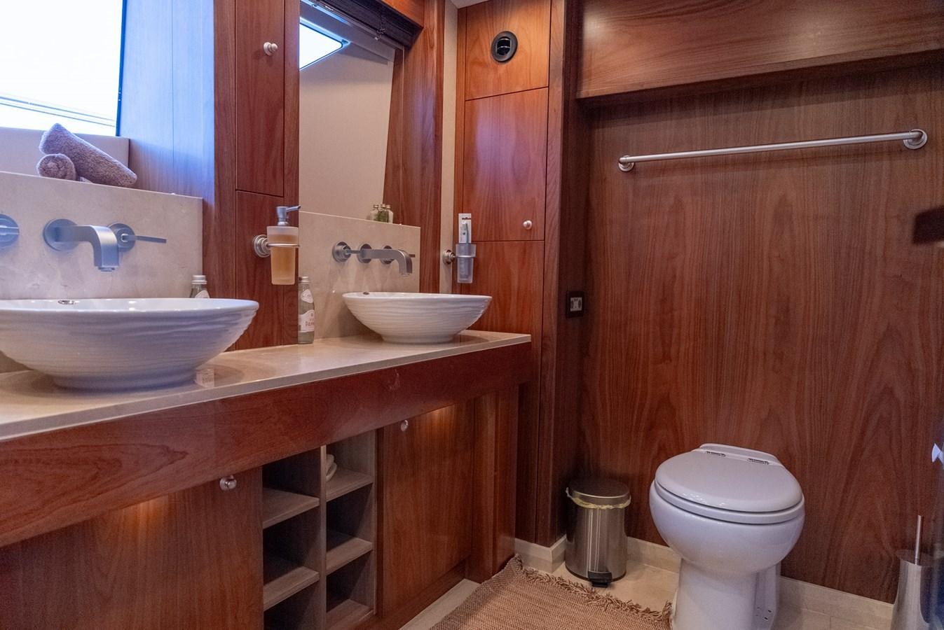 a bathroom with a sink toilet and a mirror aboard ROUND MIDNIGHT Yacht for Sale