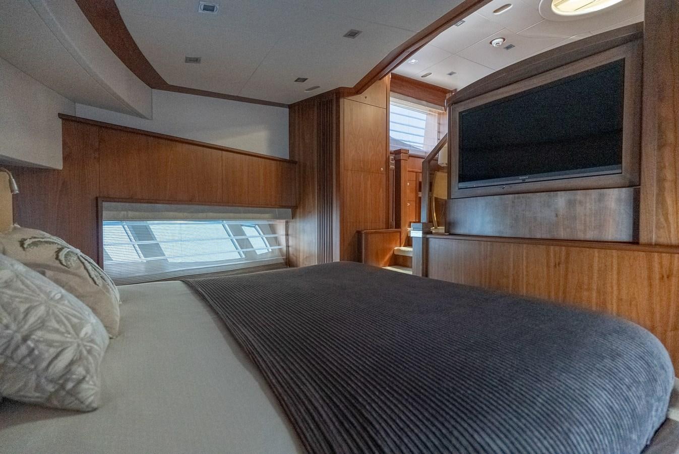 a bedroom with a bed and a television aboard ROUND MIDNIGHT Yacht for Sale