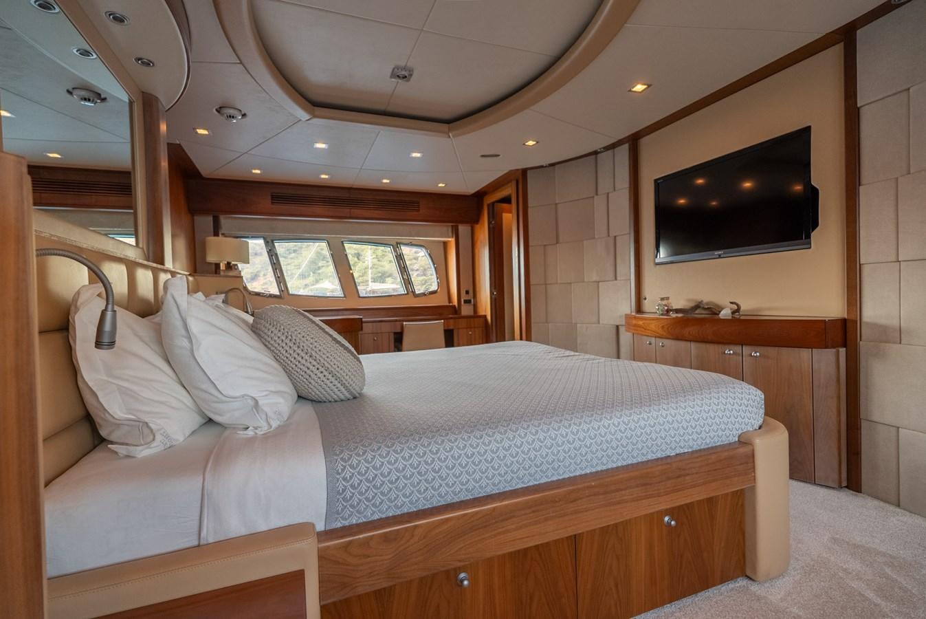 a bed with a television on the wall aboard ROUND MIDNIGHT Yacht for Sale