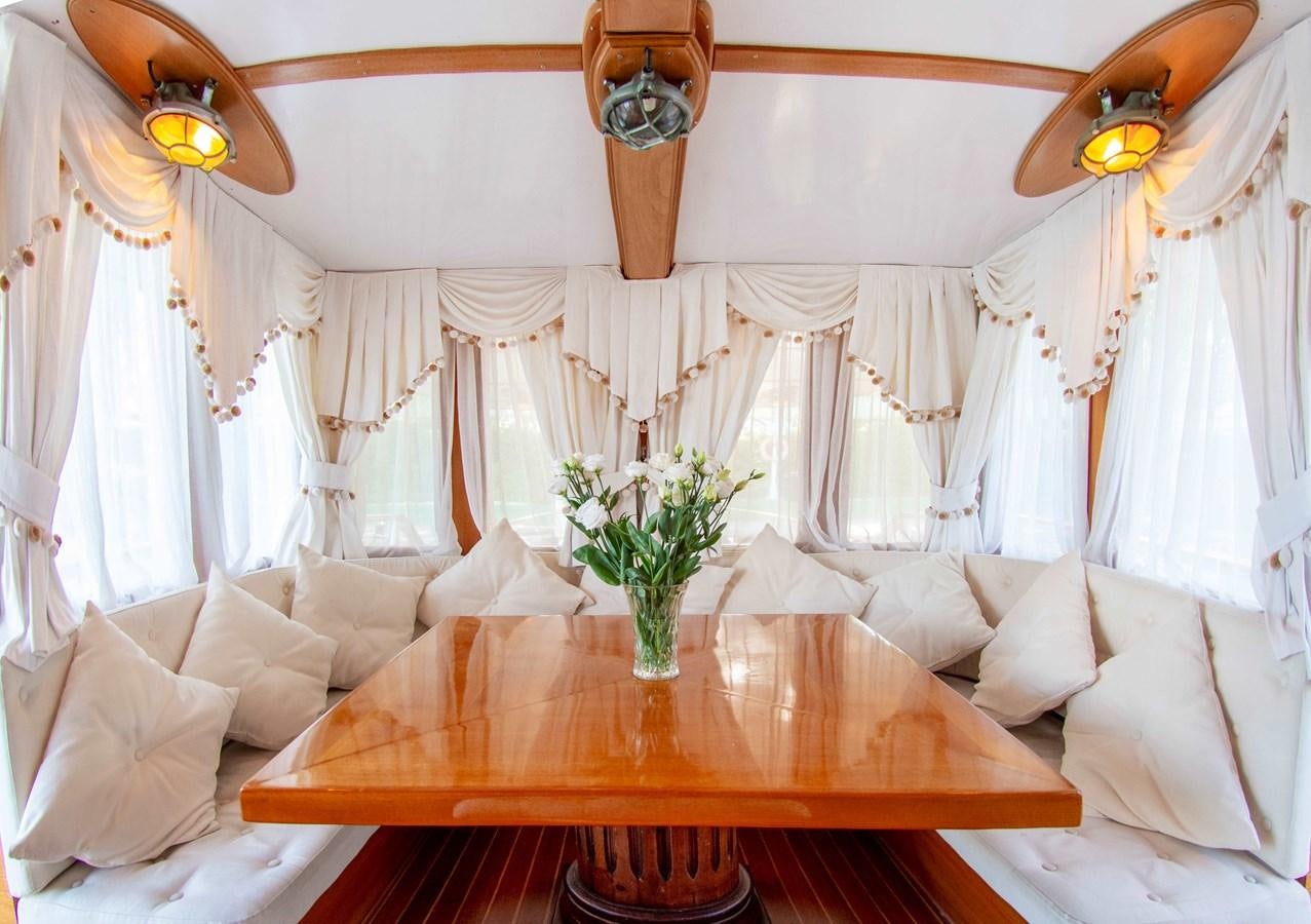 a room with a table and couch aboard FOREVER Yacht for Sale