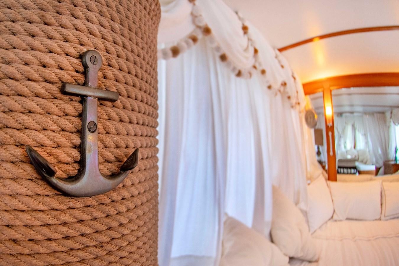 a bed with a white sheet and a white curtain aboard FOREVER Yacht for Sale