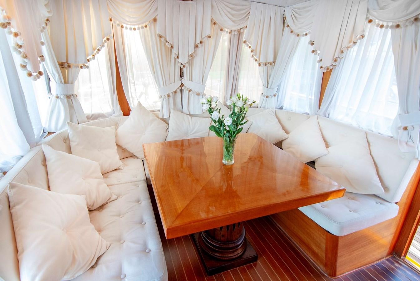 a living room with a table and couches aboard FOREVER Yacht for Sale