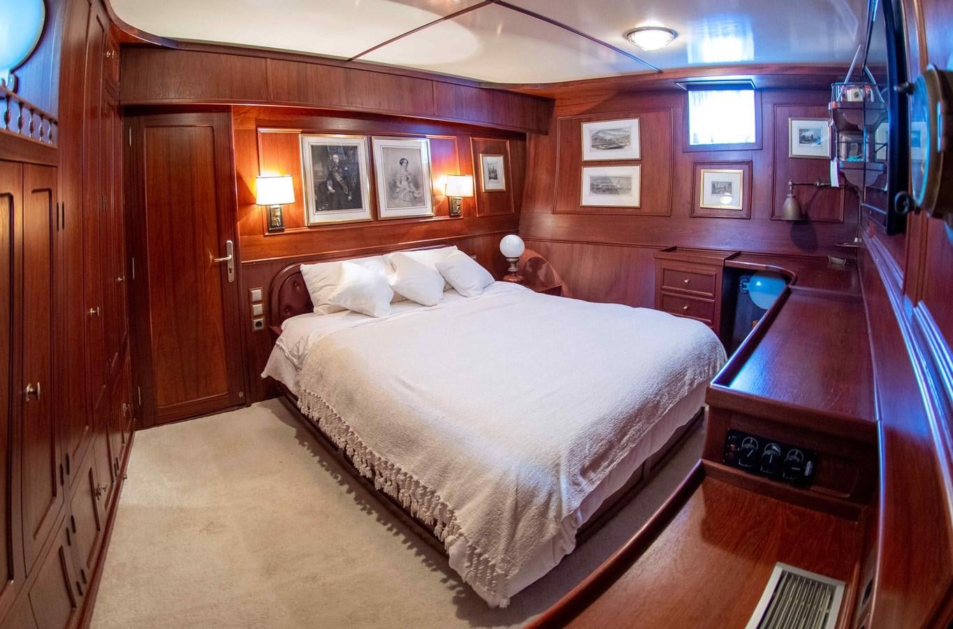 a bedroom with a bed and desk aboard FOREVER Yacht for Sale
