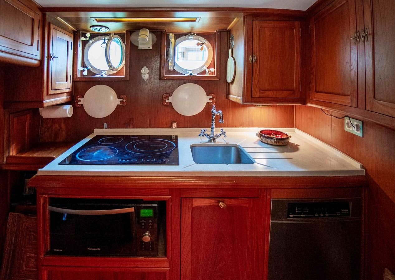 a kitchen with wooden cabinets aboard FOREVER Yacht for Sale