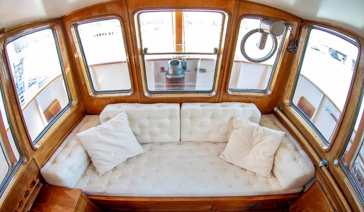 a bed with a white sheet and a window with a seat aboard FOREVER Yacht for Sale