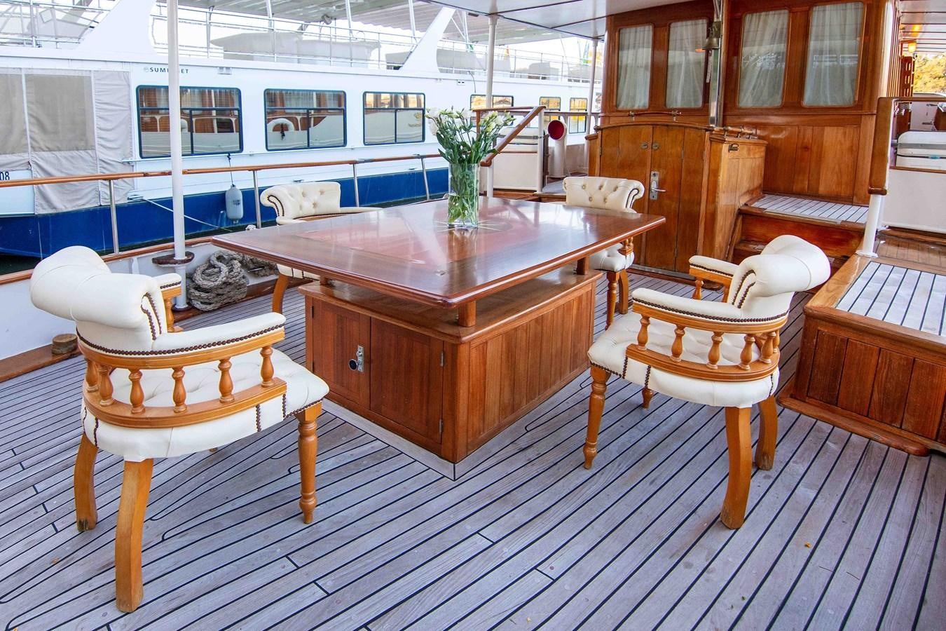 a table with chairs around it aboard FOREVER Yacht for Sale