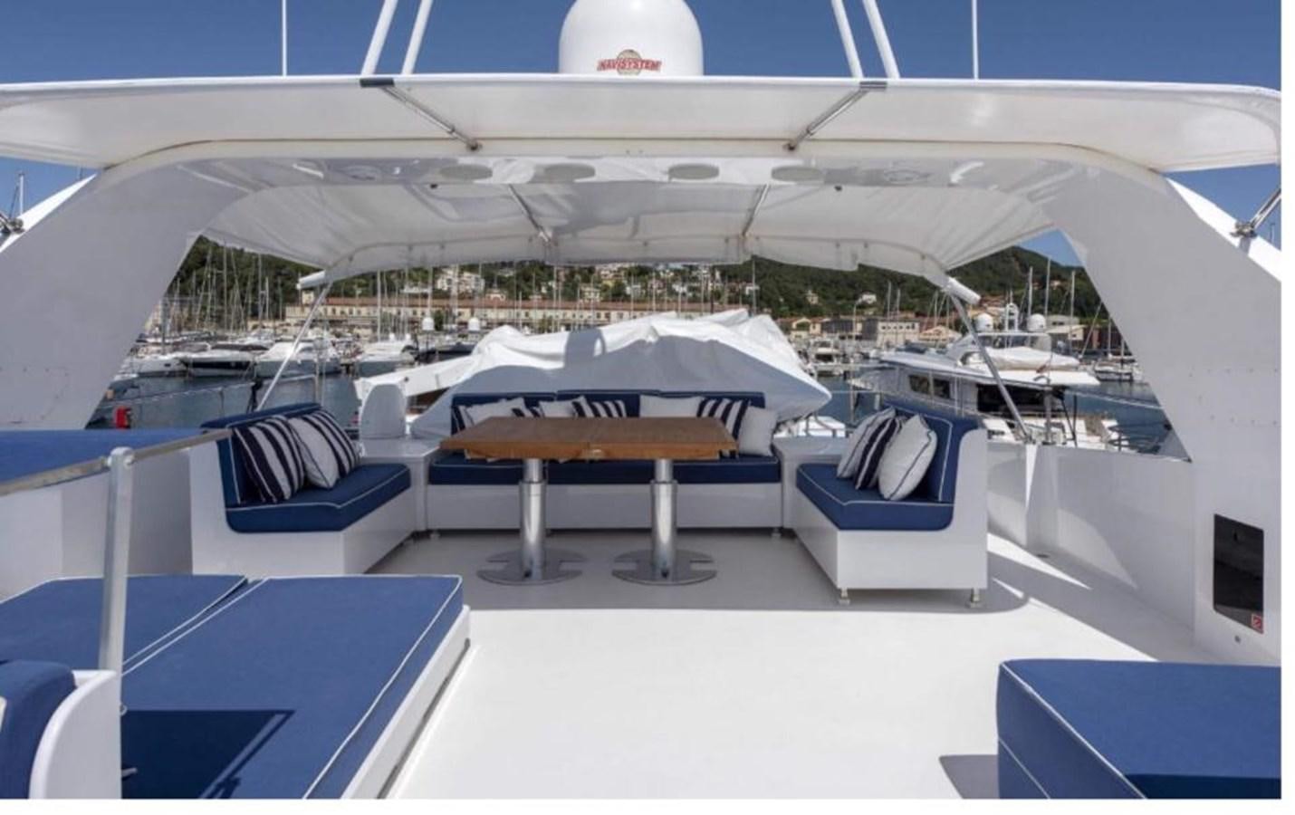 a lounge area with a table and chairs on it aboard FALCO Yacht for Sale