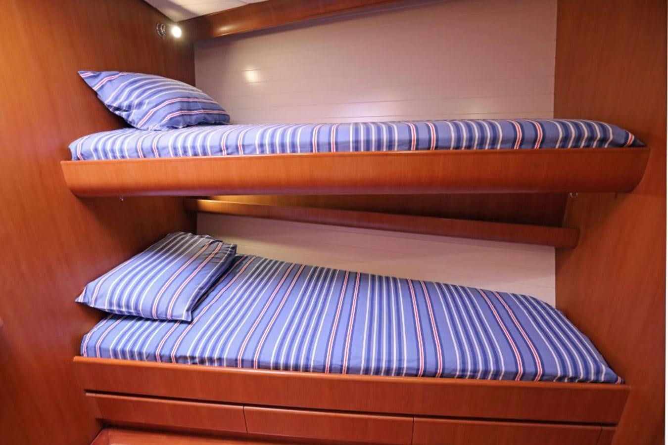 a bed with striped sheets aboard NIMROD Yacht for Sale