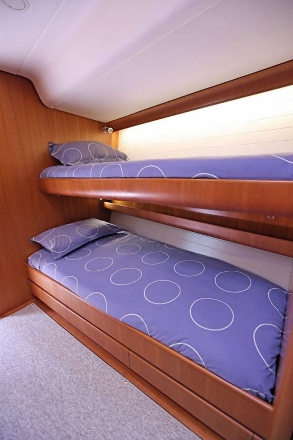 a bed with a blue comforter aboard NIMROD Yacht for Sale