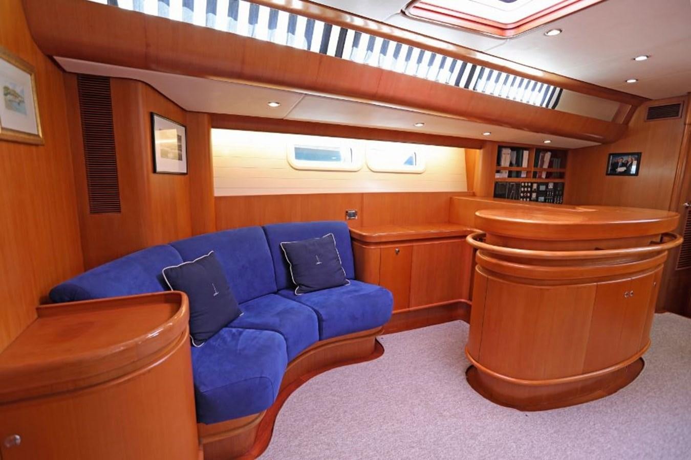 a room with a couch and a wood table aboard NIMROD Yacht for Sale
