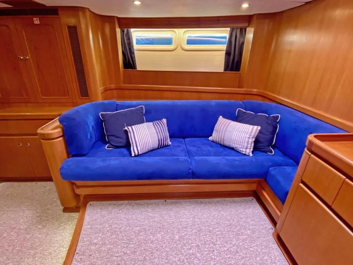 a blue couch in a room aboard NIMROD Yacht for Sale