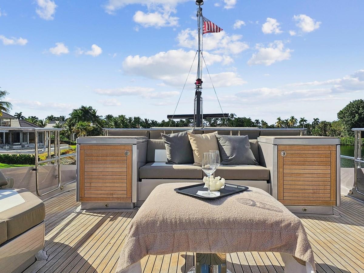 a large bed with a table and a glass of wine on it aboard IZUMI Yacht for Sale
