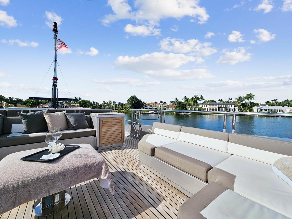 a deck with a couch and a pool and a flag on the roof aboard IZUMI Yacht for Sale